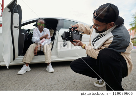 Man Recording Woman Sitting in Car Preparing for Scene 119089606
