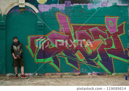 Young creative graffiti artist by wall Young creative graffiti artist by wall 119089814