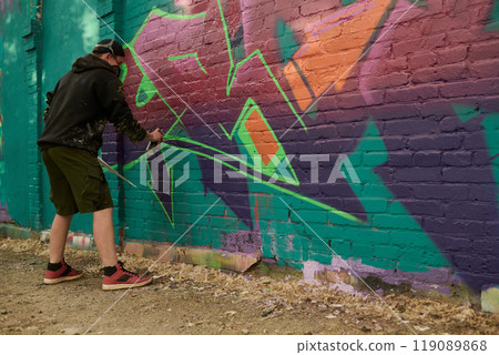Creating graffiti artwork on brick wall 119089868