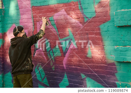 Guy creating graffiti artwork on street Guy creating graffiti artwork on street 119089874