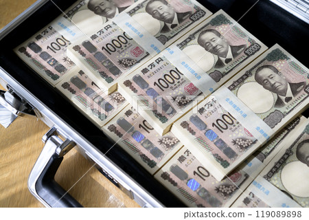 A stack of bills in an attaché case 119089898