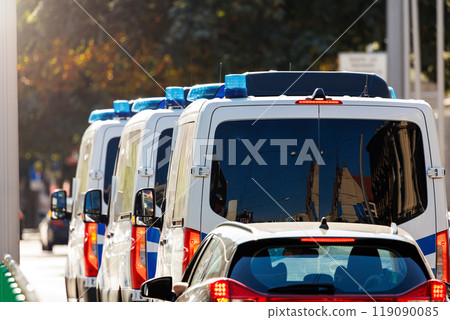 Scene back view many german police van cars drive in city urban road traffic light center downtown on sunny day. Civil emergency law security traffic service vehicle Europe. Event safety service Scene back view many german police van cars drive in city urban road traffic light center downtown on sunny day. Civil emergency law security traffic service vehicle Europe. Event safety service 119090085