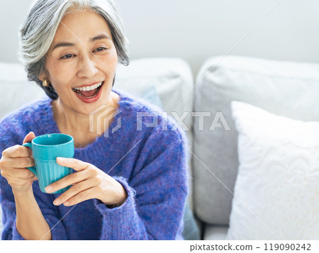 Senior woman relaxing in the living room 119090242