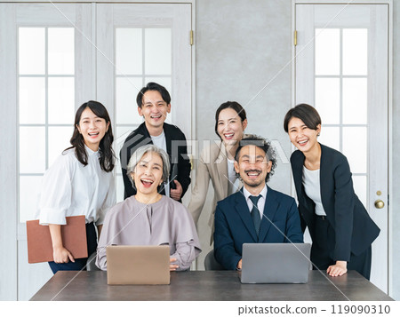 一群各代商人在辦公室裡歡笑 一群各代商人在辦公室裡歡笑 119090310