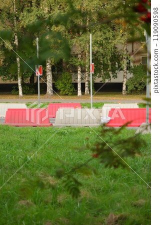 Red, white plastic safety barriers along roads. Ensuring road safety with visible barriers 119090598