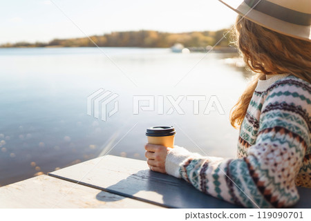 Fall concept woman drinking coffee on bench against backdrop of lake. Enjoying, solitude with nature Fall concept woman drinking coffee on bench against backdrop of lake. Enjoying, solitude with nature 119090701