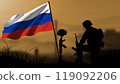 The silhouette of a Russian soldier weeps for the loss of a comrade in battle, with a large flag waving 119092206