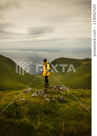 An Adventurous Hiker Standing Proudly on a Scenic Mountain Peak Overlooking Breathtaking Views An Adventurous Hiker Standing Proudly on a Scenic Mountain Peak Overlooking Breathtaking Views 119092420