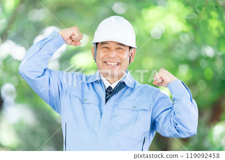 Man in work clothes, park, helmet, fist pump 119092458