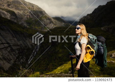 A Female Hiker Pauses to Take in the Breathtaking and Majestic Mountain Landscape  119092473