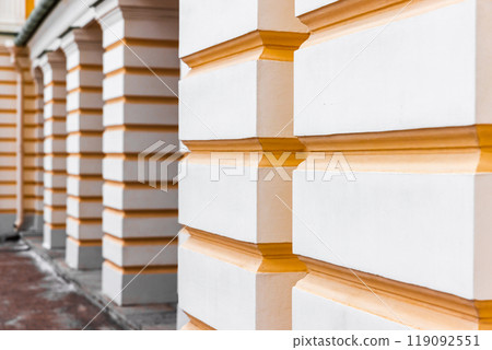 Classic architecture details, white pillars with yellow rustication stripes 119092551
