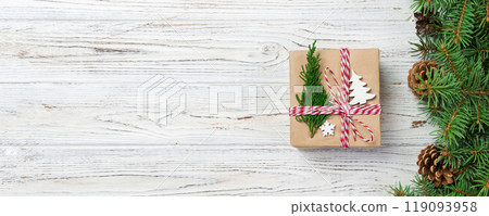 Christmas gift box wrapped in recycled paper, with ribbon bow, with ribbon on rustic background. Holiday concept Christmas gift box wrapped in recycled paper, with ribbon bow, with ribbon on rustic background. Holiday concept 119093958