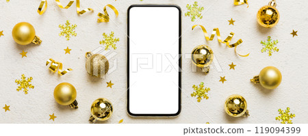 Christmas online shopping from home phone with blank white display top view. smart mobile with copy space on colored background with Christmas decorations balls,. Winter holidays sales background Christmas online shopping from home phone with blank white display top view. smart mobile with copy space on colored background with Christmas decorations balls,. Winter holidays sales background 119094399