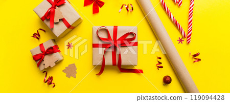 Christmas kraft gifts box with ribbon on colored background. Cozy Christmas still life, birthday or new year 119094428