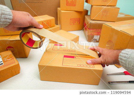 Sealed a goods box with box sealing tape for delivery to purchase order Sealed a goods box with box sealing tape for delivery to purchase order 119094594