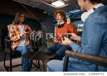 Excited teenagers talking at workplace 119094733