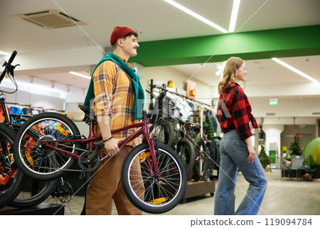 Happy man and woman married couple buying new bicycle for their child 119094784