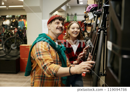 Young man and woman couple choosing bicycle at sports shop 119094786