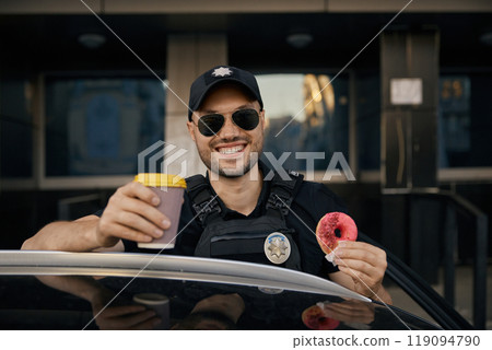 Portrait of happy patrolman drinking coffee eating donut traditional sweet Portrait of happy patrolman drinking coffee eating donut traditional sweet 119094790