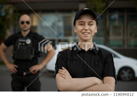 Smiling woman patrol police officer on the street Smiling woman patrol police officer on the street 119094812