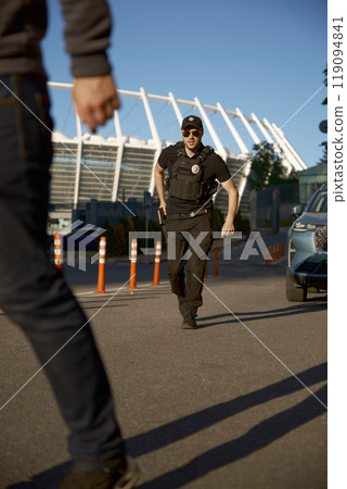 Armed policeman preparing weapon chasing criminal on city street 119094841