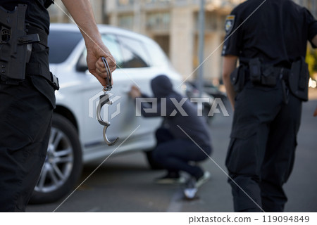 Police team catching and arresting car burglar, closeup view on handcuffs 119094849