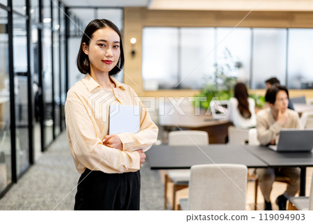 一位女士雙手拿著筆記型電腦，看著相機 119094903