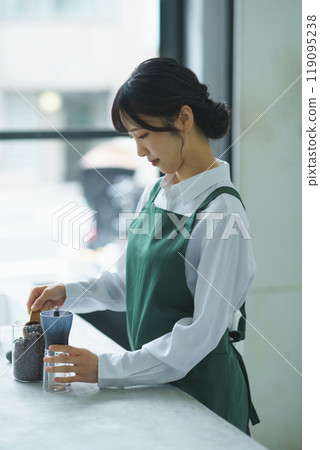 A young female sales clerk brewing coffee on a weekend morning A young female sales clerk brewing coffee on a weekend morning 119095238