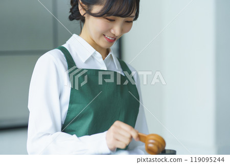 A young female sales clerk brewing coffee on a weekend morning 119095244
