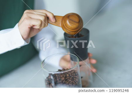 A young female sales clerk brewing coffee on a weekend morning 119095246