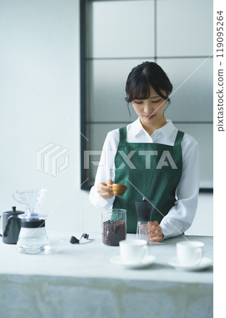 A young female sales clerk brewing coffee on a weekend morning A young female sales clerk brewing coffee on a weekend morning 119095264