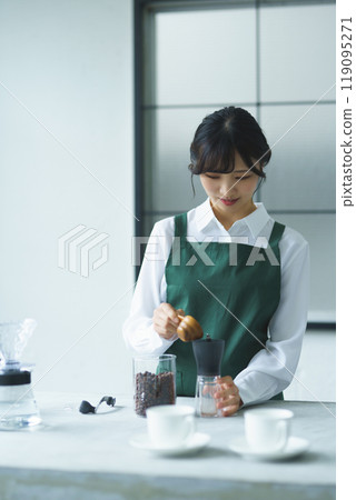 A young female sales clerk brewing coffee on a weekend morning 119095271