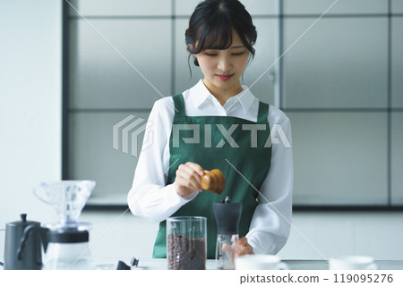 週末早上，一位年輕的女店員正在煮咖啡 119095276