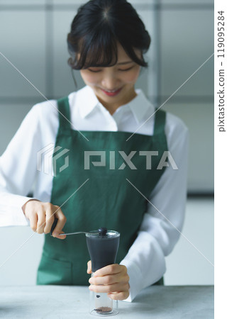 週末早上，一位年輕的女店員正在煮咖啡 119095284