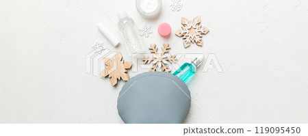 Christmas flat lay with makeup cosmetic products in cosmetic bag on colored background. Top view New year Beauty concept 119095450