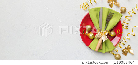 Christmas table place setting with christmas decor and plates, kine, fork and spoon. Christmas holiday background. Top view with copy space 119095464