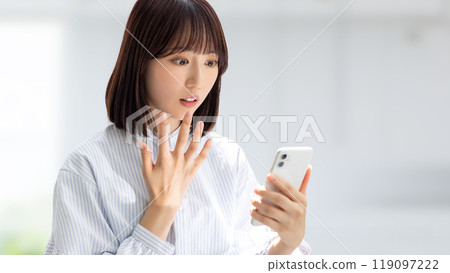Business woman surprised to see the screen of the smartphone Business woman surprised to see the screen of the smartphone 119097222