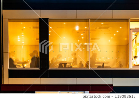 People eating and drinking at a fast food restaurant at night 119098615