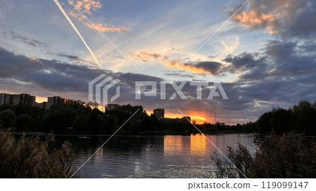 sunset over calm lake in overcast evening sunset over calm lake in overcast evening 119099147