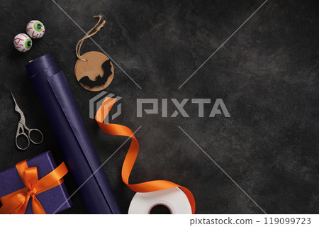 Halloween gift wrapping: pumpkins, orange ribbon, and bat decoration. Place for your text. 119099723