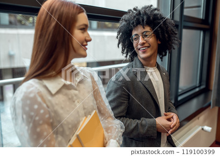 Young people talking, smiling and looking involved 119100399