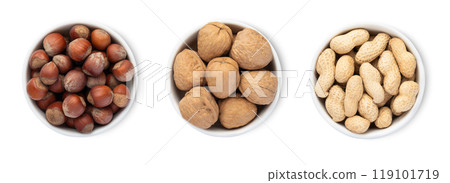 Bowl plates with hazelnut and walnut and peanut nuts with shell isolated on white background.Top view. 119101719
