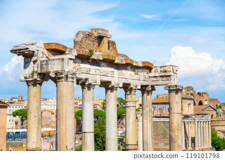 Exploring the ancient ruins of the Saturn Temple located in the Roman Forum, Rome. The remnants showcase impressive columns against a clear blue sky, reflecting the grandeur of ancient architecture. 119101798