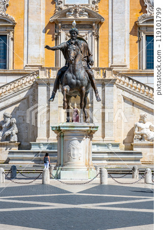 The captivating equestrian statue of Marcus Aurelius stands prominently on Capitoline Hill, showcasing the emperor in a commanding pose against the backdrop of ancient architecture. 119101799