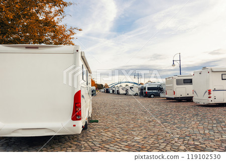 Scenic view many campers motorhome parked at camping site at Elbe river embankment Passenger trip cruise ship docked morning sunrise sky. Motorhome station travel destination. RV lifestyle 119102530