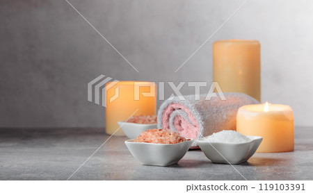 Sea salt, towels, and burning candles on a grey background. Sea salt, towels, and burning candles on a grey background. 119103391
