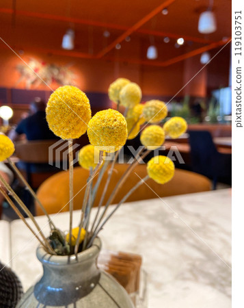 Table with decorative vase and condiment set in cozy restaurant ambiance. Warmth and elegance of a dining table setting, highlighting the intricate details of the decorations Table with decorative vase and condiment set in cozy restaurant ambiance. Warmth and elegance of a dining table setting, highlighting the intricate details of the decorations 119103751