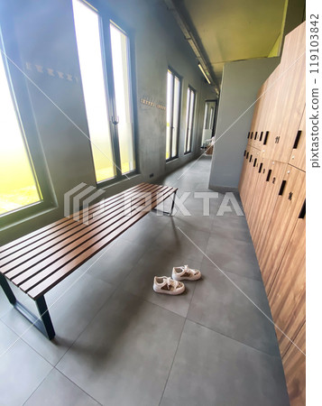 Wooden bench in empty locker room at gym Wooden bench in empty locker room at gym 119103842