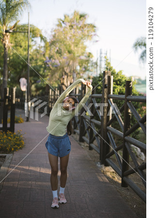 A Joyful and Cheerful Young Woman Happily Enjoying a Bright and Sunny Day Outdoors in Nature A Joyful and Cheerful Young Woman Happily Enjoying a Bright and Sunny Day Outdoors in Nature 119104279