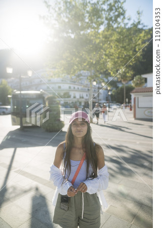 A Trendy and Fashionable Young Woman in a Beautiful Sunlit Urban Setting Enjoying Life 119104353